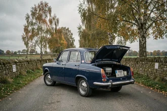Renault 8 bleue vintage garée sur une route rurale française, vue grand angle mettant en valeur sa carrosserie compacte et ses chromes d'époque