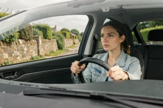 Jeune conductrice dans une voiture d'auto-école sur une route typique des Côtes-d'Armor