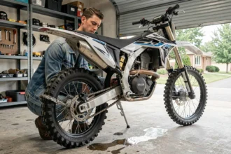 Homme sécurisant sa moto cross avec un antivol chaîne dans un garage résidentiel